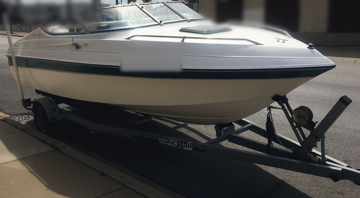 Cuddy cabin boat on its trailer at the curb, ready for a driveway service call